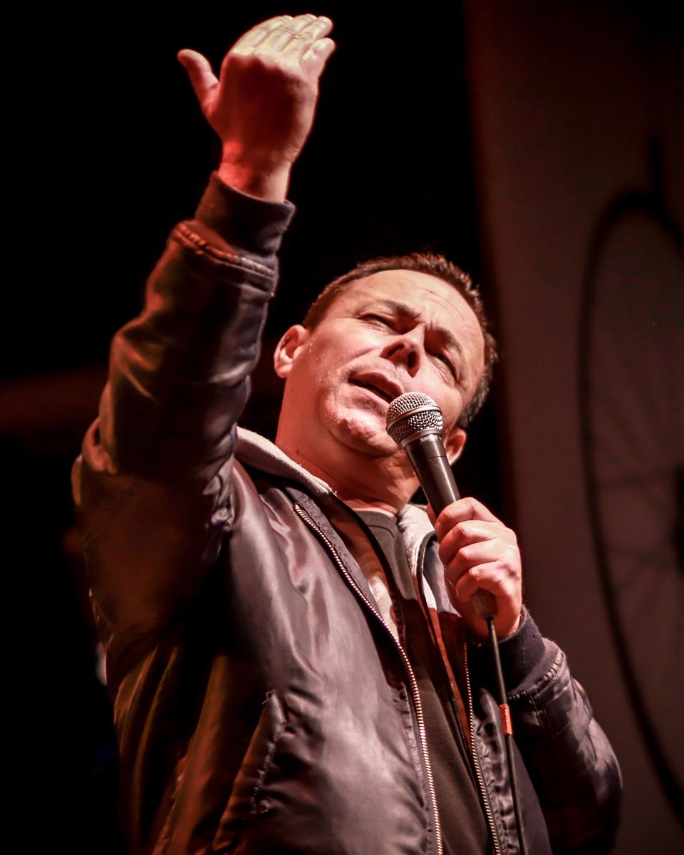Raúl Broughton haciendo stand up en el escenario, micrófono en mano