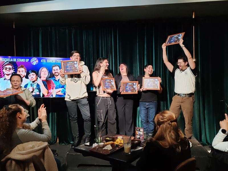 Egresados de la escuela celebrando con sus diplomas en el show de egreso